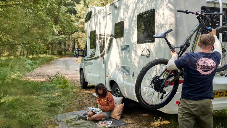 Man taking a mountain bike off a camper van